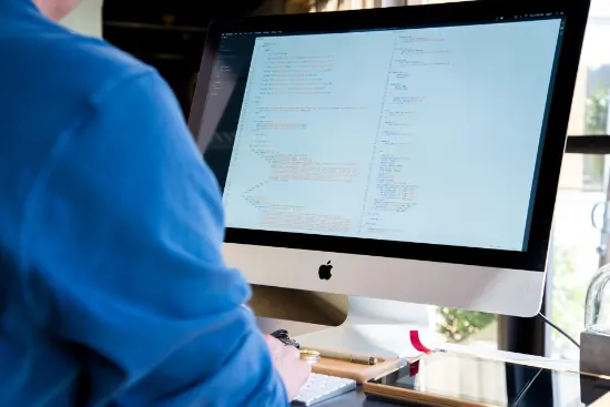 A person working at a computer writing computer code.
